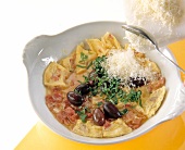 Olive basil and cheese being added to eggs, cream, ham and tomatoes in bowl