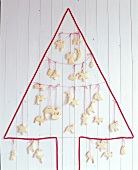 Wall Christmas tree from red cord hanging on strings across with cookies