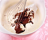 Close-up of butter and chocolate mixture in bowl with whisk