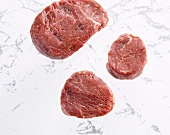 Different size of three raw steaks