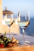 Two glasses of white wine with salad on plate in Mallorca, Spain