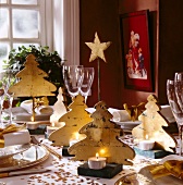 Gedeckter Tisch, dekoriert mit golde nen Sternen und Weihnachtsbäumen