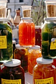 Close-up of various type of jars with honey and pickle fruits in syrup