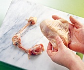 Close-up of man's hand holding raw chicken