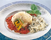 Vegetables stuffed in fish rolls with rice and tomato sauce on plate
