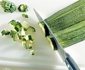 Close-up of zucchini cut into quarters with knife