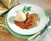Ox tongue with raisin sauce and dumpling on plate