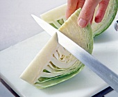 Cabbage cut with knife on cutting board