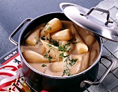 Teltow turnips garnished with herbs in saucepan with lid
