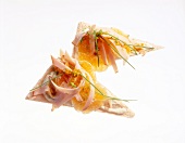 Crisp bread with turkey breast, chives and mandarin on white background
