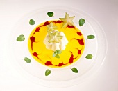 Apricot puree with vanilla cream and karambola on plate decorated with herbs