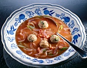 Bowl of onion soup with meatballs and tomato paste