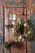 Wreath of vine clematis hanging on old wooden door