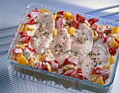 Turkey cutlets with red and yellow peppers in glass baking dish