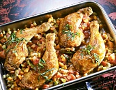 Golden brown chicken legs with vegetables in tray