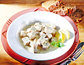 Veal stew with white sauce and lemon on plate