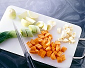 Sliced carrots and vegetables on chopping board