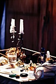 Nachttisch mit Kerzen, Creme, Wasser u. a., dunkel, Nahaufnahme