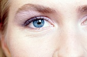 Extreme close-up of blue eyed woman wearing subtle eye make-up