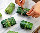 Rolling cabbage leaf with kitchen twine rope