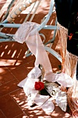 Pink stockings, shoes and rose on floor beside chair