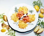 Two rosti with salmon, cottage cheese, dill, caviar, potatoes and parsley on plate