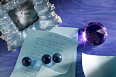 Picture frames, letter and paperweight ball on purple background