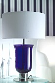 Close-up of white lamp shade with blue glass base