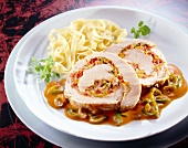 Roast turkey roll with chilli-cheese filling and noodles on plate