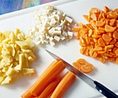 Chopped potatoes, celery and carrots on chopping board