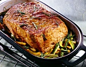 Roast veal with gorgonzola cheese, zucchini and rosemary in roasting pan