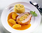 Roasted veal stuffed with rice, oregano and orange sauce on white plate