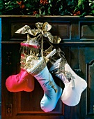 Close-up of red, blue and white stockings decorated with gold ribbon bows