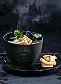Hot Asian squid soup in black bowl