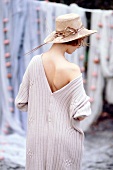 Rear view of woman wearing big v-necked sweater and hat