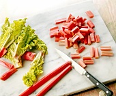 Rhubarb being chopped on chopping board to prepare fruit sauce