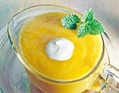 Yellow fruit sauce with peach and mango in sauce boat