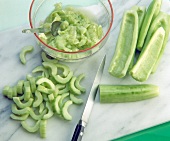 Halved cucumbers being cut into slices