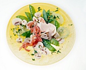 Champignon-Salat mit Zuckererbsen u. Lachsschinken auf Teller in Gelb