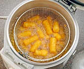 Close-up of croquettes in deep fryer