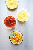 Garlic mayonnaise, tomato and mango chutney and vinaigrette in bowls