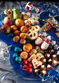 Different type of fruits and marzipan cookies on plates