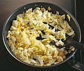 Close-up of Chinese cabbage strips in frying pan