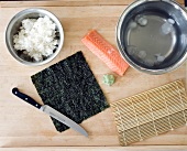 Sushi-Reis, Lachs, Bambusmatte, nigiri-Blatt, Eiswürfel und 1Messer