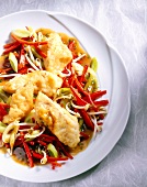 Fish fillets with pepper, bean sprouts and various vegetables on plate