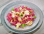 Red cabbage salad with pear and walnuts on glass plate