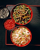Beef with green beans, sesame seeds and fried rice with ham and shrimp in bowls