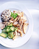 Sliced turkey with wild rice, mushrooms and zucchini on plate