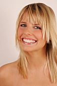 Portrait of happy blonde woman with shoulder length hair and fringes smiling broadly