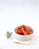 Chicken legs with tomato marinade in bowl